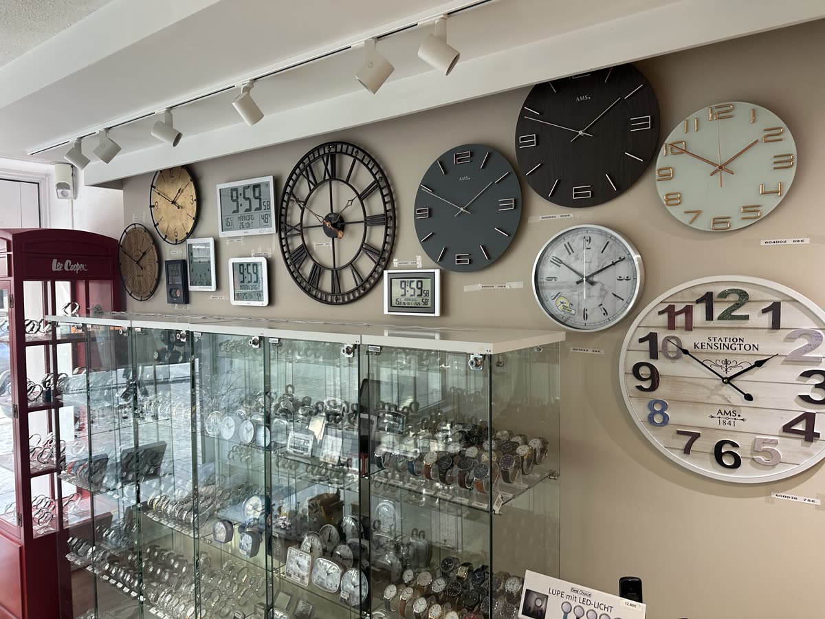 Vitrine met horloges en een wand vol klokken